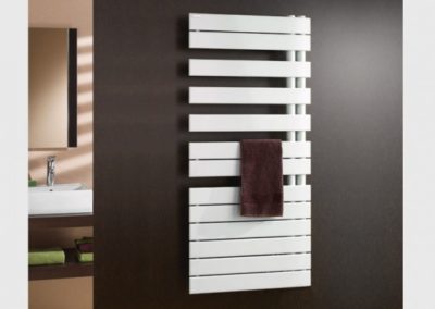 sèche serviette blanc sur un mur marron avec une serviette marron pendue